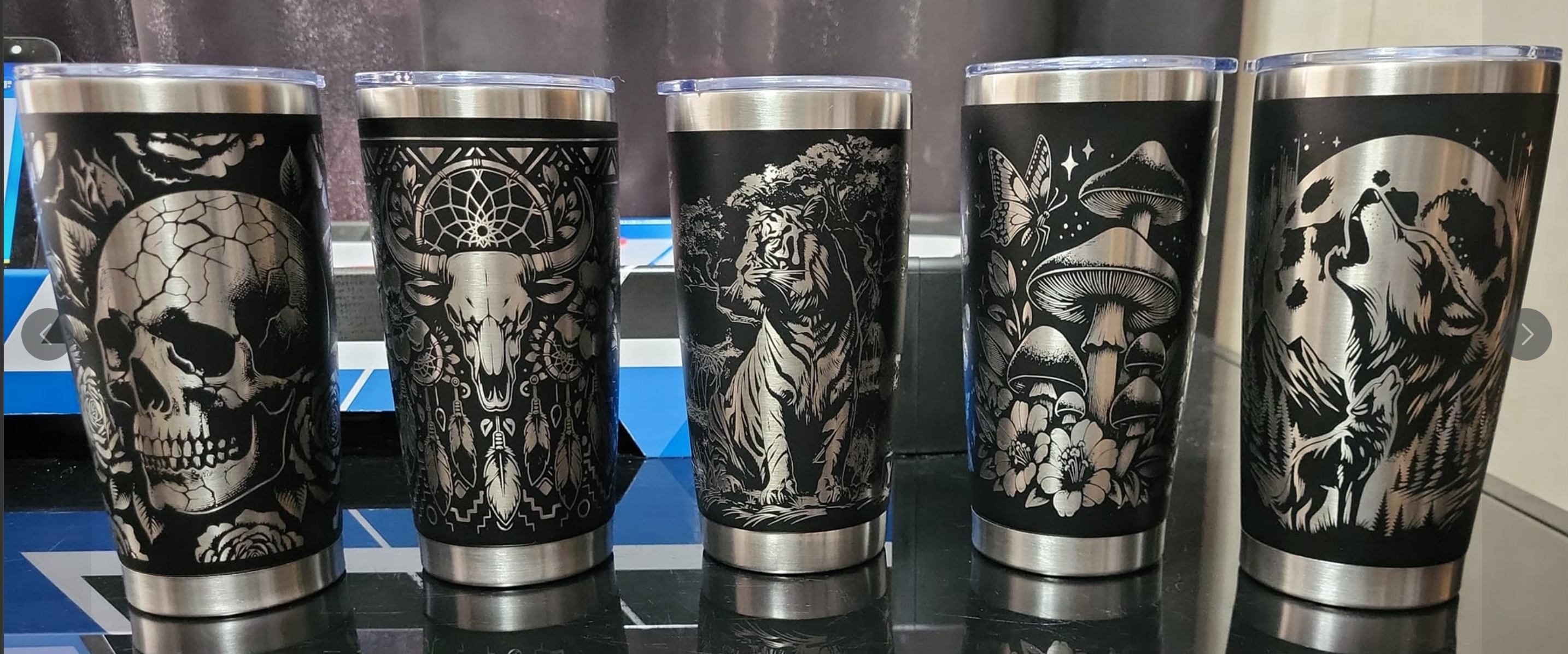 Five stainless steel tumblers with engravment designs on the tumblers